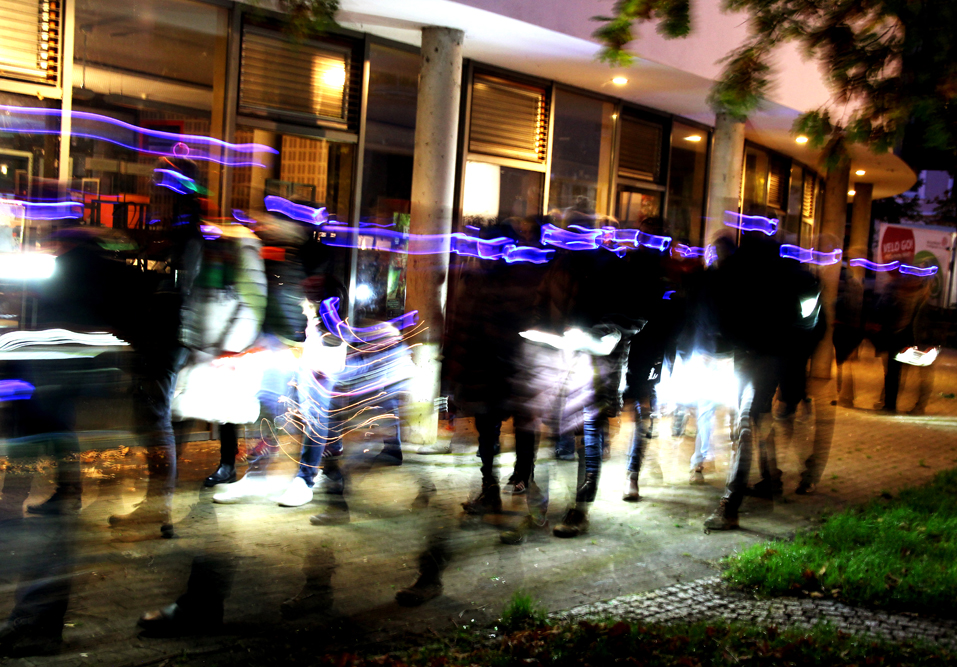Unscharfes Bild von einem beleuchteten Menschzug durch die Straßen Gröpelingens
