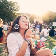 Frau macht Seifenblasen auf einem Festival